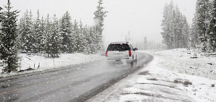 Auto ajaa lumisella tiellä